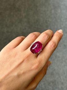 Make a statement with this unique and beautiful pink, sugarloaf shaped rubellite tourmaline and diamond three stone cocktail ring. The center stone is a certified startling pink colored natural tourmaline, weighing 16.25 carats, and the side stones are white diamonds VS quality weighing total 0.66 carats. The ring is currently sized at US 7, can be resized. The metal used is solid 18K Rose Gold.  18K Pink Gold : 6.08 Grams  Rubellite : 16.25 Ctw Diamond : 0.66 Ctw Elegant Pink Ruby Gemstones, Luxury Tourmaline Gemstones With Accent Stones, Luxury Tourmaline Gemstones With Gemstone Accents, Luxury Tourmaline Cabochon Rings, Elegant Pink Ring With Large Stone, Elegant Pink Ruby Cabochon Ring, Elegant Pink Cabochon Ruby Ring, Vvs Diamond, Rubellite Tourmaline