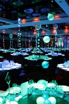 a room filled with lots of tables covered in white and blue balloons