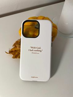 a white cell phone case sitting on top of a table next to a glass of milk