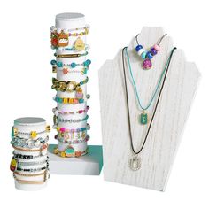 a jewelry display with bracelets, necklaces and rings on it's stand