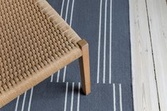 a chair sitting on top of a wooden floor next to a blue and white rug