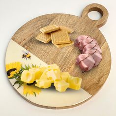 a wooden cutting board topped with sliced ham and waffles next to sunflowers