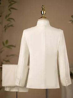 a mannequin wearing a white suit with gold buttons on the lapel and collar