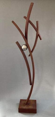 a wooden sculpture with a metal ball on it