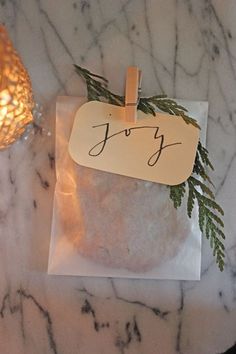 a bag with a tag that says joy on it sitting next to a small candle