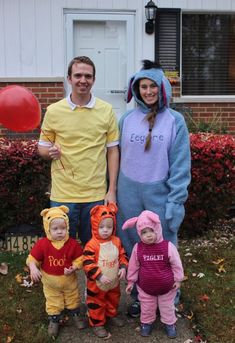 two adults and three children dressed up as winnie the pooh, tigger, tigger and tigger