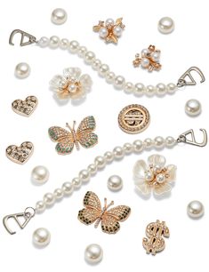 an assortment of jewelry including pearls, brooches and other items on a white background