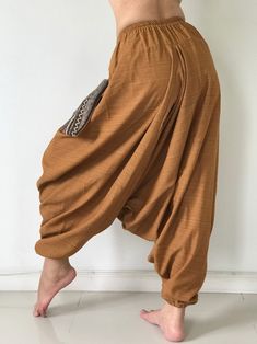 "These super soft rayon baggy unisex harem pants have the \"flow\", perfect of yoga or just a cool strolling. Comfort and character are what these pants are all about. They have the traditional sarong look & feel but a lot more practical when it comes to activity like yoga. As a bonus, they are convertible! Just pull them up and you get yourself a cute jumpsuit in a flash. Together with elastic cuff legs, you can wear them short or long. The pants have smock waist (wide bang elastic) with no Casual Harem Parachute Pants For Yoga, Baggy Harem Yoga Pants For Loungewear, Hippie Harem Pants For Loungewear, Relaxed Fit Drop Crotch Harem Pants For Yoga, Yoga Harem Pants With Drop Crotch And Relaxed Fit, Hippie Style Harem Pants For Loungewear, Yoga Harem Pants With Drop Crotch, Baggy Yoga Pants With Drop Crotch, Baggy Brown Harem Pants With Elastic Waistband