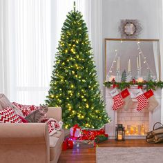 a living room decorated for christmas with a cat sitting on the couch next to it