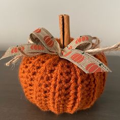 an orange crocheted pumpkin with a ribbon on it