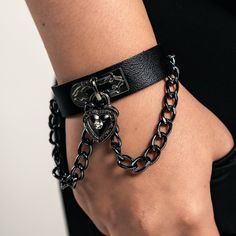 Black Leather Wristband with Heart Padlock Elevate your style with our Black Leather Wristband, measuring 8.5 inches in length and 1.75 inches in width. This piece features a stained metallic chain and a heart-shaped padlock, adding a touch of edgy elegance to your look. Designed for comfort and versatility, this wristband is not too bulky, making it perfect for daily wear. Whether you're dressing up or keeping it casual, this wristband is a standout accessory that complements any outfit. Edgy Bracelet Strap Jewelry Gift, Black Punk Chain Bracelet As A Gift, Edgy Jewelry Bracelet Strap As Gift, Edgy Jewelry Bracelet Strap Gift, Edgy Jewelry With Bracelet Strap For Gift, Black Punk Style Chain Bracelet For Gift, Black Punk Style Chain Bracelet As Gift, Punk Style Black Chain Bracelet Gift, Edgy Bracelets With Adjustable Chain