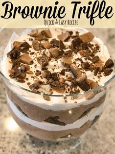 a brownie trifle in a glass dish with whipped cream and chocolate chips