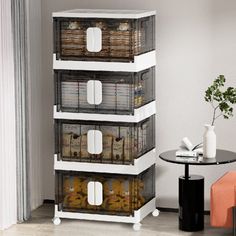 the four tiered storage unit is filled with plastic containers and baskets, along with a small round table