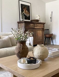 a living room filled with lots of furniture and flowers on top of a coffee table