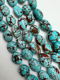 several turquoise and brown beads on a white surface