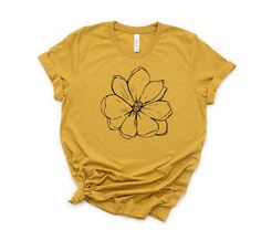 Must have summer shirt! This T-shirt is so adorable for your summer wardrobe! Our shirts are great for your summer outings and makes a great gift. This cute magnolia tee is a must. We use a high-quality unisex t-shirt that is insanely soft. In fact, it will be one of the softest, best fitting, most comfortable shirts you've ever owned CLICK BELOW https://www.etsy.com/shop/WalnutRidgeCo DETAILS: - Design is printed using Direct to Garment (DTG) print technology. Ink is injected into the fabric le Summer Floral Print T-shirt For Everyday, Floral Print T-shirt For Summer, Simple Crew Neck Shirt For Spring, Yellow Spring Shirt With Screen Print, Spring Yellow Shirt With Screen Print, Yellow Screen Print Shirt For Spring, Spring Everyday Tops With Plant Print, Everyday Spring Tops With Plants Print, Yellow T-shirt For Spring