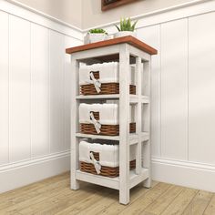 a white shelf with baskets and towels on it next to a wooden floor in a room