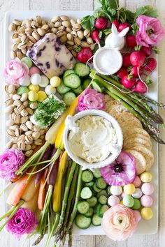 a platter filled with different types of vegetables and dip surrounded by other food items