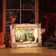 a christmas scene is displayed in front of a window