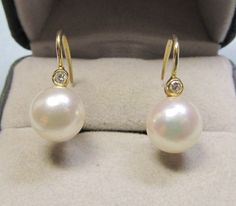 A classic pair of diamond and pearl earrings from the 1960's is set in 14Kt yellow gold with a European lever backs. These earrings can be worn dressy for occasions or sporty with jeans or basically all the time. The well matched high luster cultured pearls measure 7 millimeters and the approximate total weight of the two full cut diamonds is 0.08Ct. Classic Hallmarked Diamond Earrings For Formal Occasions, Classic Hallmarked Diamond Earrings For Formal Events, Classic Yellow Gold Diamond Earrings For Evening, Classic Round Diamond Earrings For Evening, Yellow Gold Round Diamond Earrings With Pearl Drop, Formal Yellow Gold Diamond Earrings With Pearl Drop, Formal Yellow Gold Pear-shaped Pearl Earrings, Classic Pear-shaped Yellow Gold Diamond Earrings, Classic Pearl Earrings With Diamond Accents For Evening