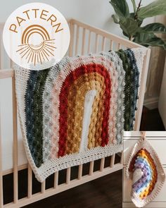 there is a crocheted blanket with a rainbow on it and a pot holder next to it