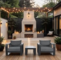 an outdoor living area with two chairs and a fire place in the middle of it