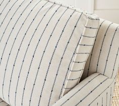 the back of a striped couch with blue pinstripe on it's fabric