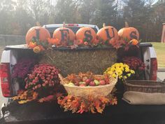 a truck with pumpkins and flowers in the back