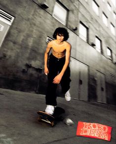 a young man riding a skateboard next to a red sign that says rob's drum