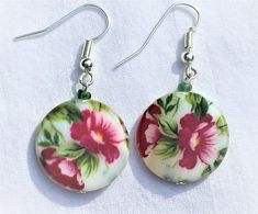 Red flower green leaves on white background beautiful gentle flower earrings. The color pattern is painted on mother pf pearl coin shaped shell beads. Available with lever back or fish hook (shown) closure - please choose.  Drop length 1.5 inches, bead size 19 mm.  These earrings make a perfect gift for a gardener who likes to plant flowers, or to a florist, or to any woman who likes flowers!  TO VIEW MY ENTIRE SHOP GO TO: https://www.etsy.com/shop/Voleena Fish Hooks Show, Background Beautiful, Flower Green, Red Flower, Shell Beads, Fish Hook, Flower Earrings, Red Flowers, Green Leaves