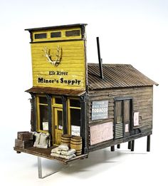 a miniature model of a store with an old fashioned sign on the front and side