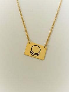 a gold necklace with a black circle on it