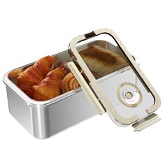 an open metal container with bread and croissants in it on a white background