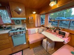 a kitchen area with a table, stove and oven in it next to a window