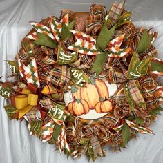 a wreath with pumpkins and leaves on it