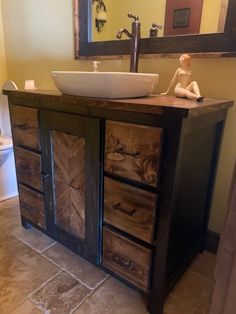 a bathroom with a sink, mirror and wooden cabinet in the corner that is made out of wood