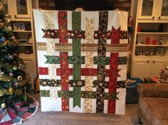 a christmas tree is next to a large quilt