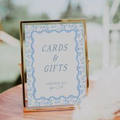 a card and gifts sign sitting on top of a wooden table