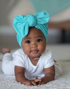 an adorable baby wearing a blue bow on her head