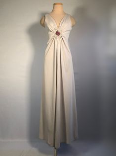 "1970s Sleeveless maxi dress with elegant deep V neckline, gathers at the bust decorated with a diamond of lace and needlepoint upon a lovely simple maxi dress. This dress is in great shape, no snags, holes or stains. Bust 36\", waist 30\", hips 50\", empire waist 11\" front and 13\" back, lenght 53\"," Vintage V-neck Evening Maxi Dress, Beige V-neck Evening Dress For Formal Occasions, Beige Floor-length Maxi Dress For Prom, Elegant Lined Maxi Dress, Vintage V-neck Evening Dress For Formal Occasions, Vintage Beige V-neck Maxi Dress, Vintage V-neck Maxi Dress For Formal Occasions, Vintage V-neck Evening Dress, Lined Maxi Length Evening Dress