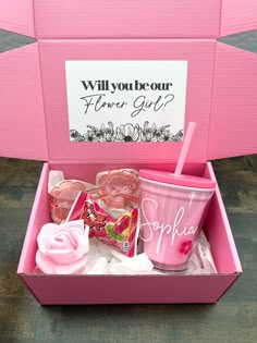 a pink box filled with lots of different types of cups and candy in it's lid