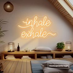 a neon sign that reads,'unhale exhale'on the wall above a bed