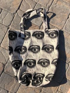 a black and white bag with eyes on it sitting on top of a stone floor