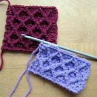 two crocheted squares sitting next to each other on top of a wooden table