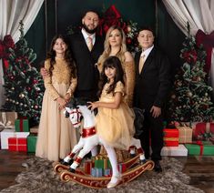 a family posing for a christmas photo in front of presents