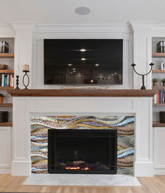 a living room with a fire place and bookshelves on either side of the fireplace