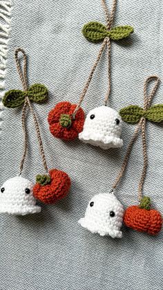 three crocheted ghost ornaments hanging from twine