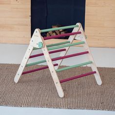 a child's wooden play set with ladders and logs in front of a fireplace