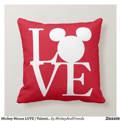 a red pillow with the word love in mickey mouse's head on top of it