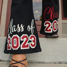 "Take your style to the next level with our Graduation Flare Jeans, featuring a variety of denim shades and colors. Perfect for any occasion, these jeans will have you standing out from the crowd in a playful and fashion-forward way. (And they'll make your booty look bomb!) #JeansGoals" Black Senior Pants, Senior Jeans Red And Black, Hoco Painted Jeans, Homecoming Jeans Decorated, Graduation Jeans, Spirit Jeans Ideas, Hoco Jeans Painted, Senior Jeans Ideas High Schools, Senior Pants Ideas